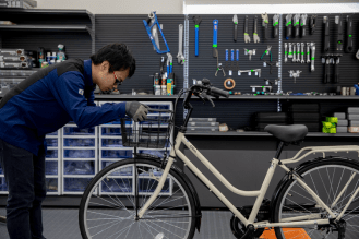 自転車のハンドルを調整するスタッフの手