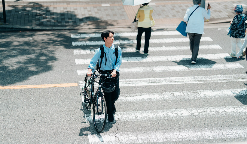 自転車と一緒に歩くビジネスマン